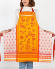 Orange fruit jacquard apron with red trim; white side panels show small fruit icons.