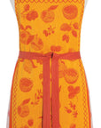 Fruit jacquard apron in bright orange with fruit pattern, red neck strap and tie waist.