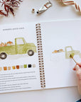 Autumn watercolor workbook open to pumpkin patch truck painting page with color swatches