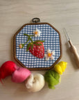 Wool felting supplies: embroidery hoop with strawberry panel, plus red, pink, cream and green roving