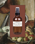 Brown room spray bottle with pump sprayer, white label reading Harvest Kitchen