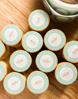 Round lip butter balm tins with mint-green lids and illustrated leaf labels