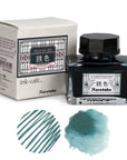Japanese ink bottle with box and teal ink swatches, Kuretake Kuroganeiro