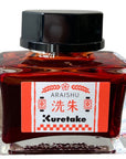 Japanese ink bottle with black cap, red glass ink, and cream front label