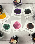 Multiple ink bottles and color swatch cards on tabletop, Chrome Yellow card visible