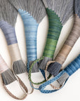Tampico wing brush close-up with gray bristles and blue green striped wraps