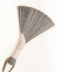 Gray tampico wing brush with pink striped wrap and leather loop handle