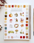 Autumn watercolor workbook open to instruction page with watercolor illustrations and swatches