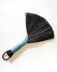 Tampico wing brush with dark bristles, light blue handle, and black leather cord loop