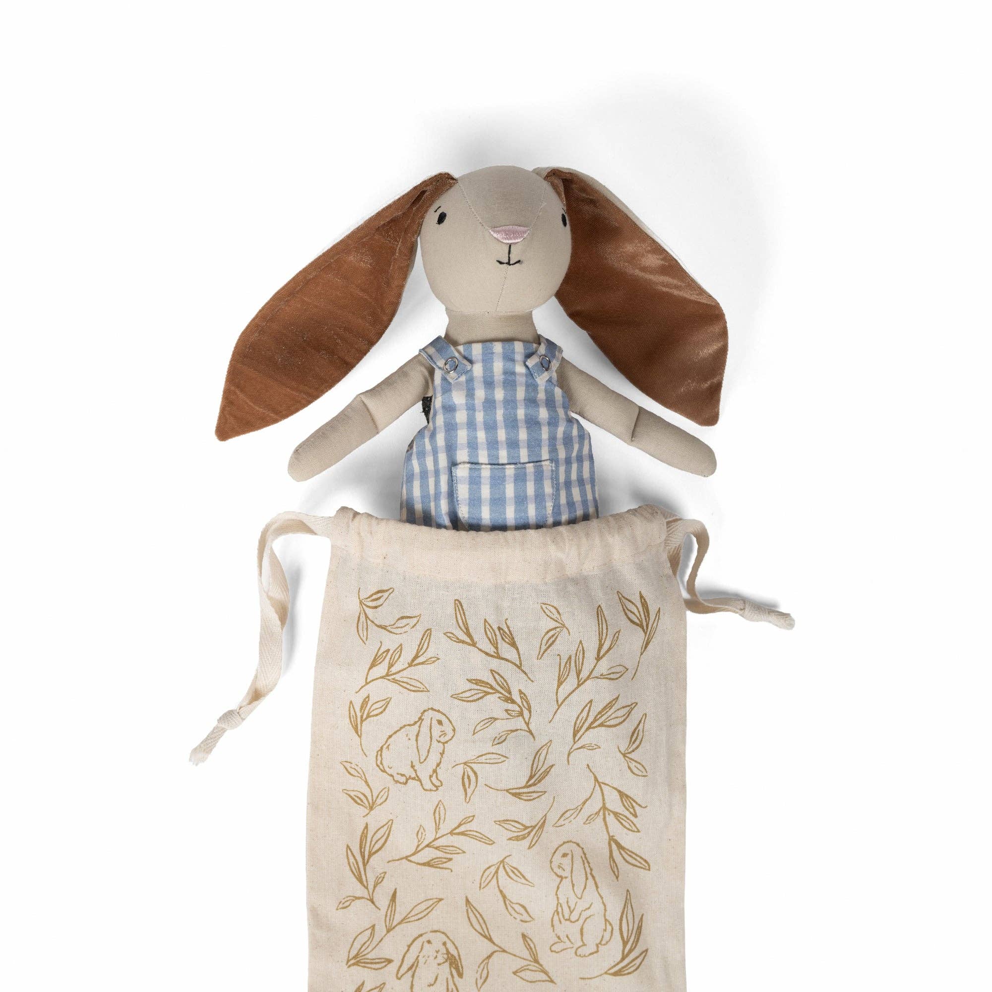 Rabbit plush doll in blue striped overalls with brown ears, in a leaf-print tote