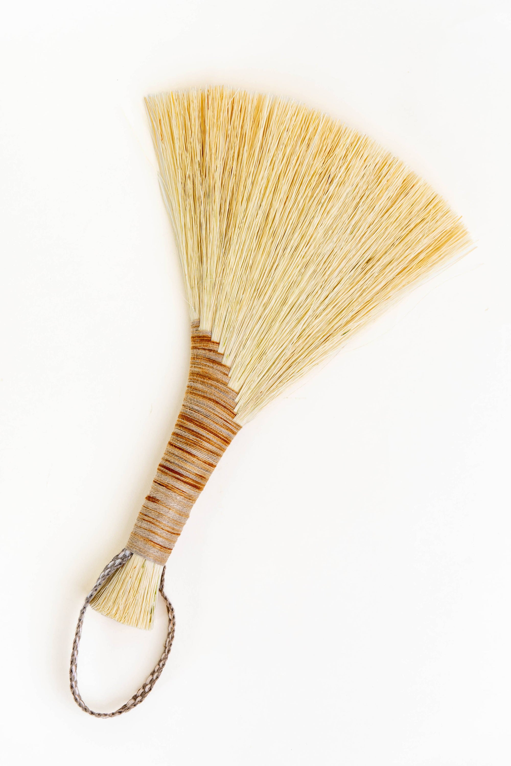 Wing broom with brown leather cord and light tan tampico bristles