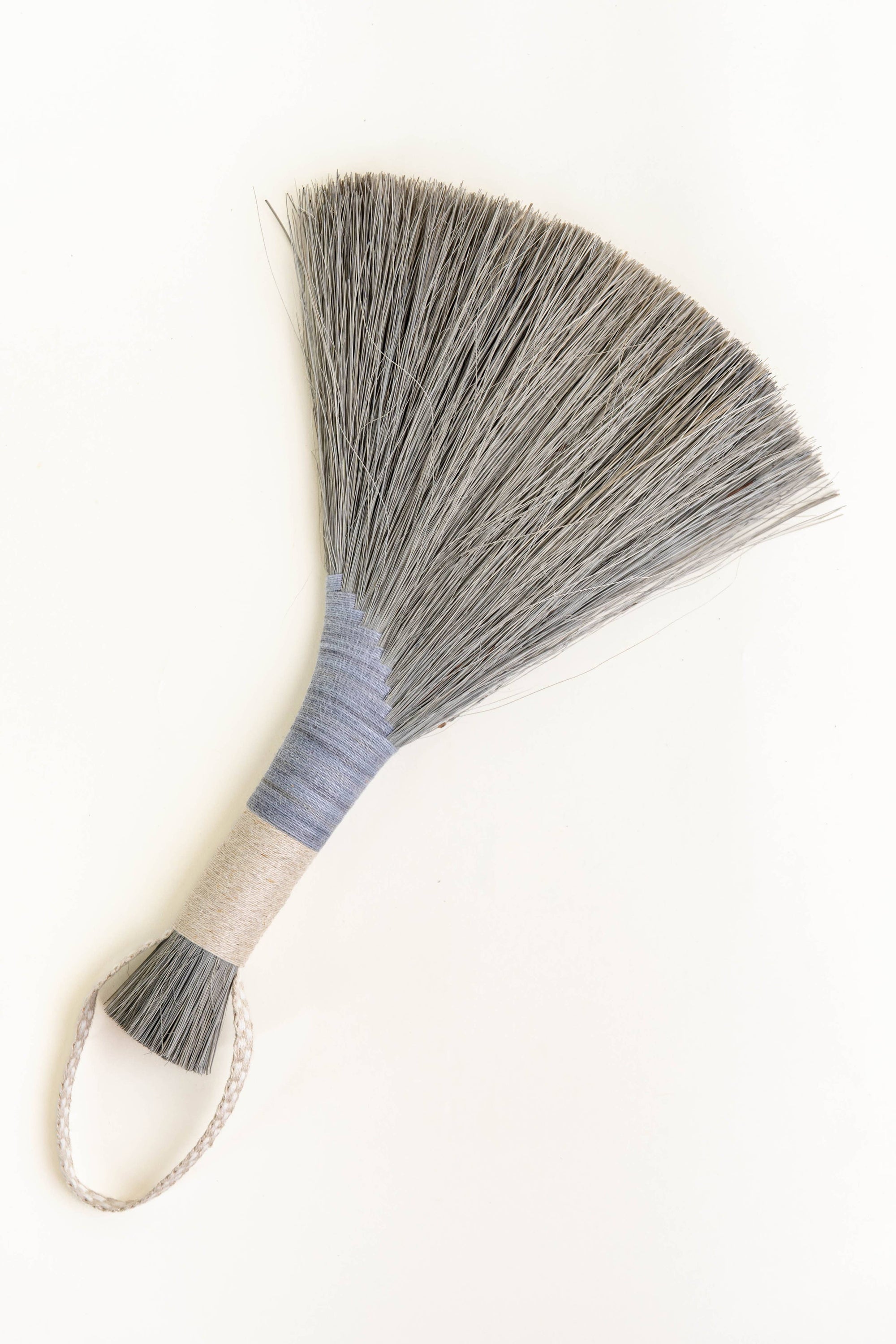 Handheld wing broom with gray fiber head, light blue wrapped handle, and white cord loop