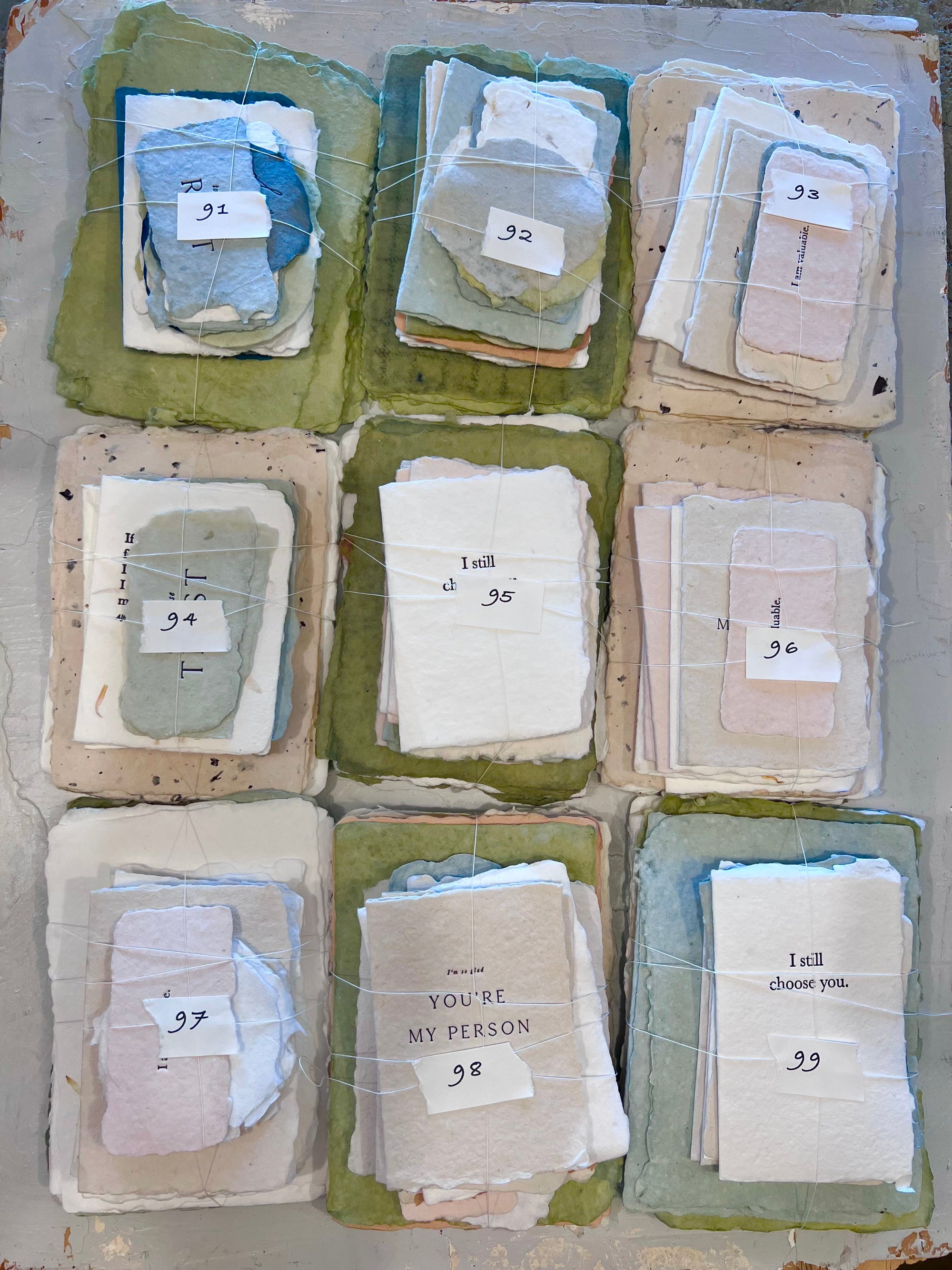 Assorted fabric bundle stacks (91–99) in clear sleeves