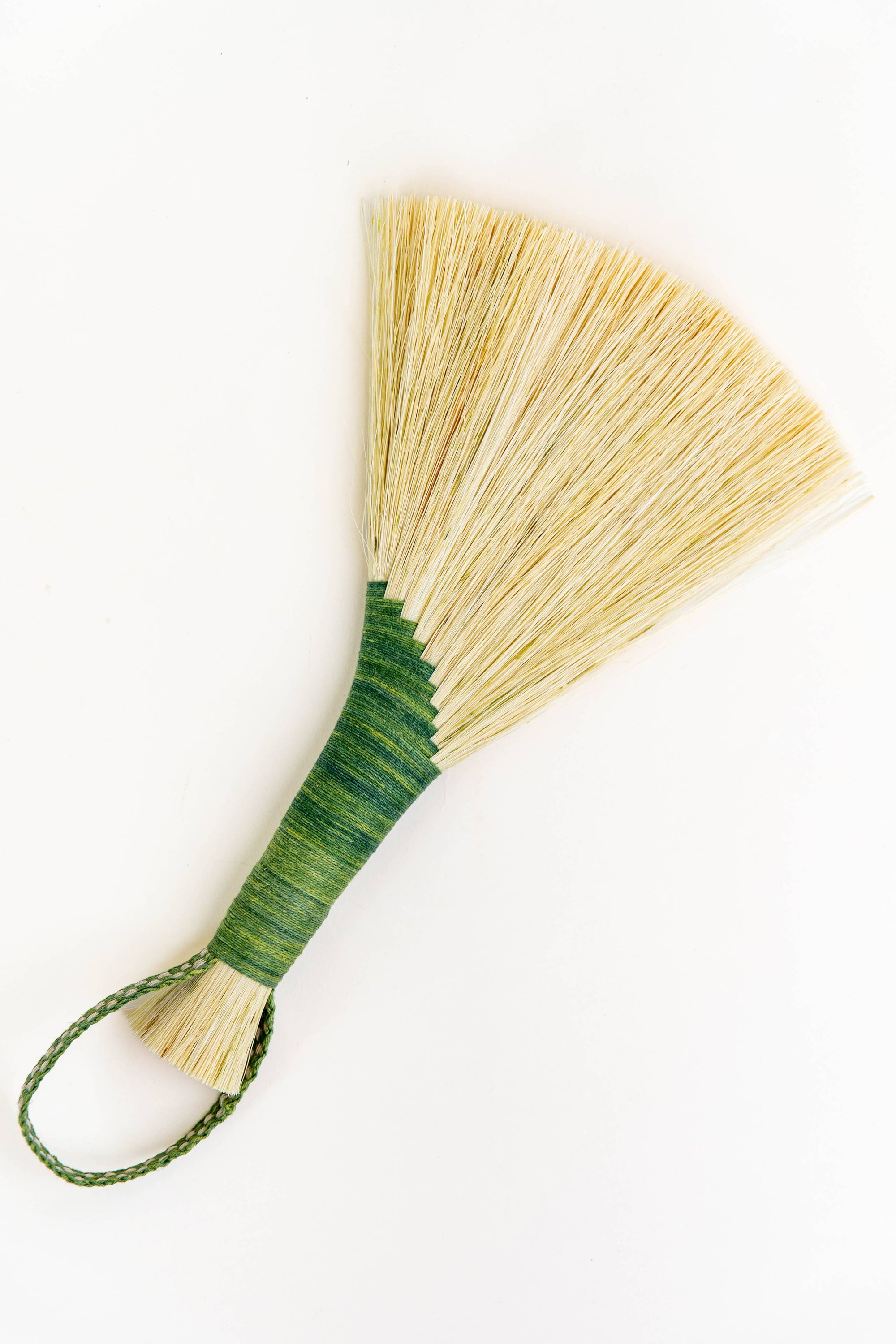 Wing broom with green wrapped handle and brown cord loop