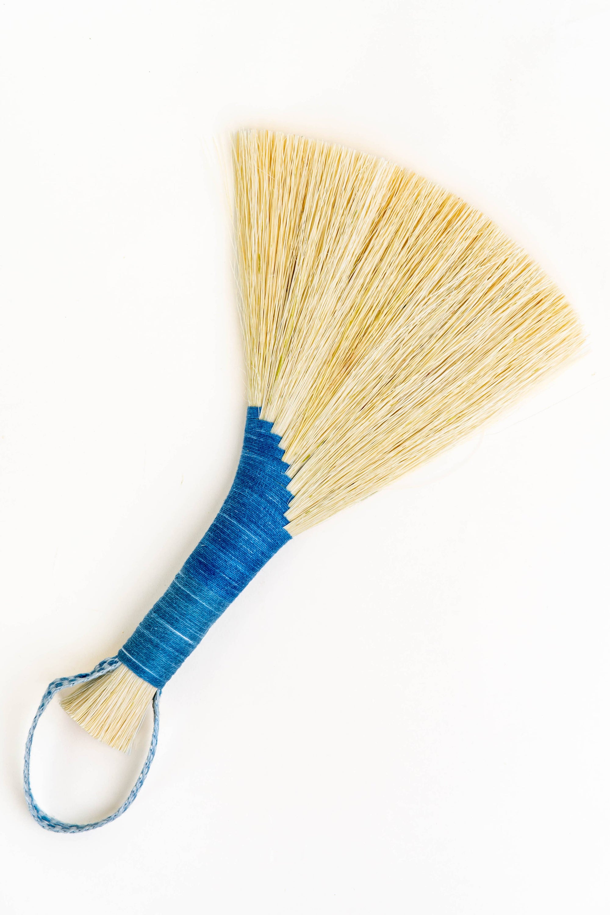 Wing broom with light blue cord loop and light tan tampico bristles