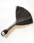 Tampico wing brush with dark bristles, silver-gray handle, and black leather cord loop