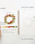 Autumn watercolor workbook open pages showing watercolor paper, sketch, and lay-flat binding