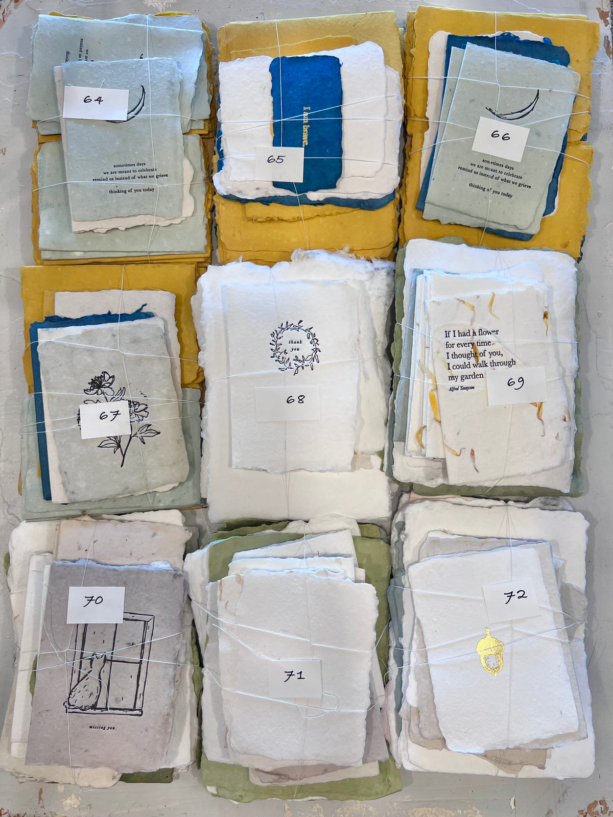 Assorted numbered paper bundles in blue, white, and yellow sleeves, stacked together