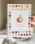 Autumn watercolor workbook cover with pumpkin illustration and watercolor color swatches