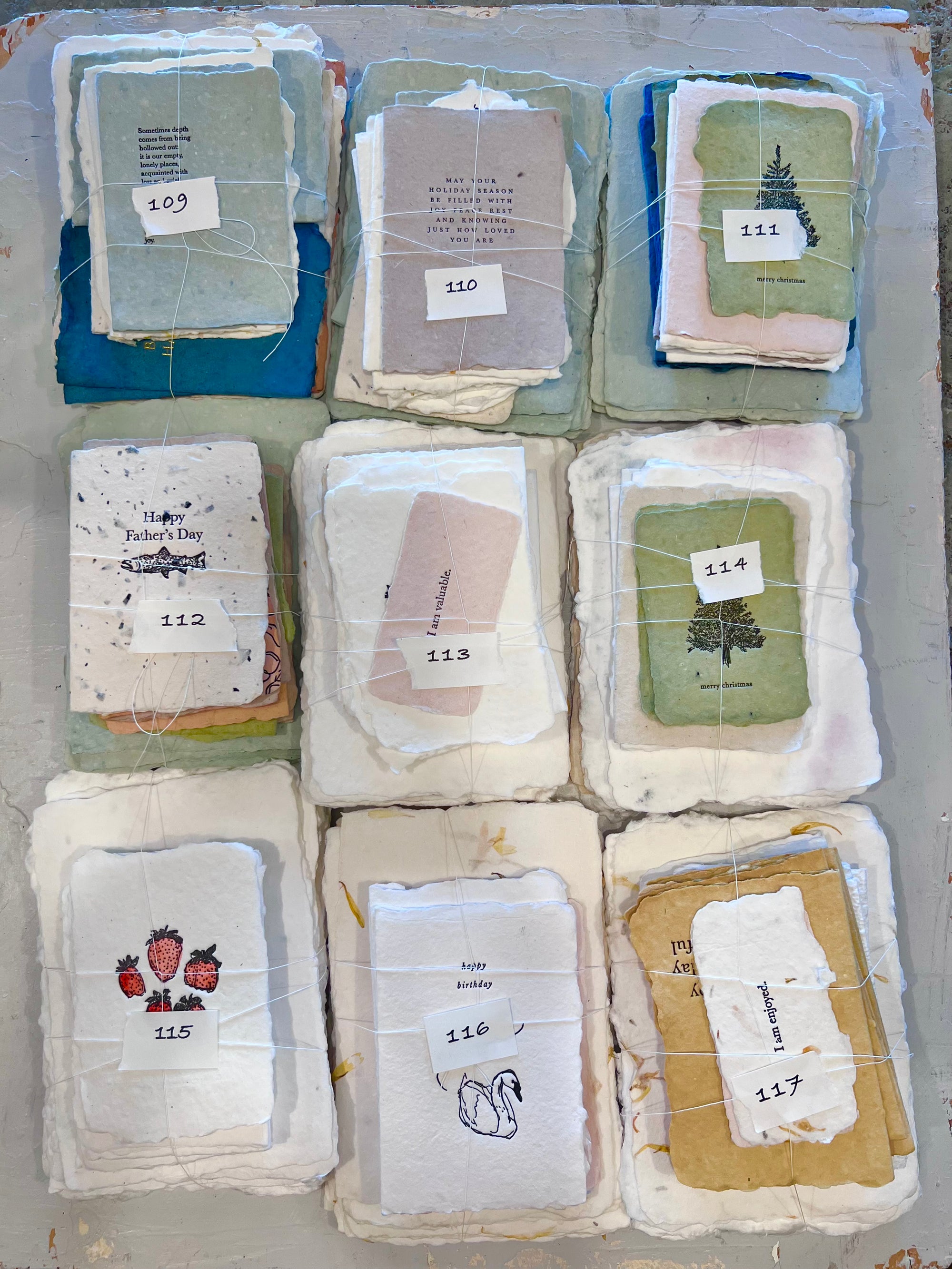 Assorted odds fabric bundle, nine folded cloth sets labeled 109–117