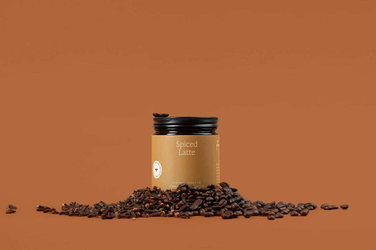 Amber Spiced Latte beeswax jar candle with black lid and scattered coffee beans