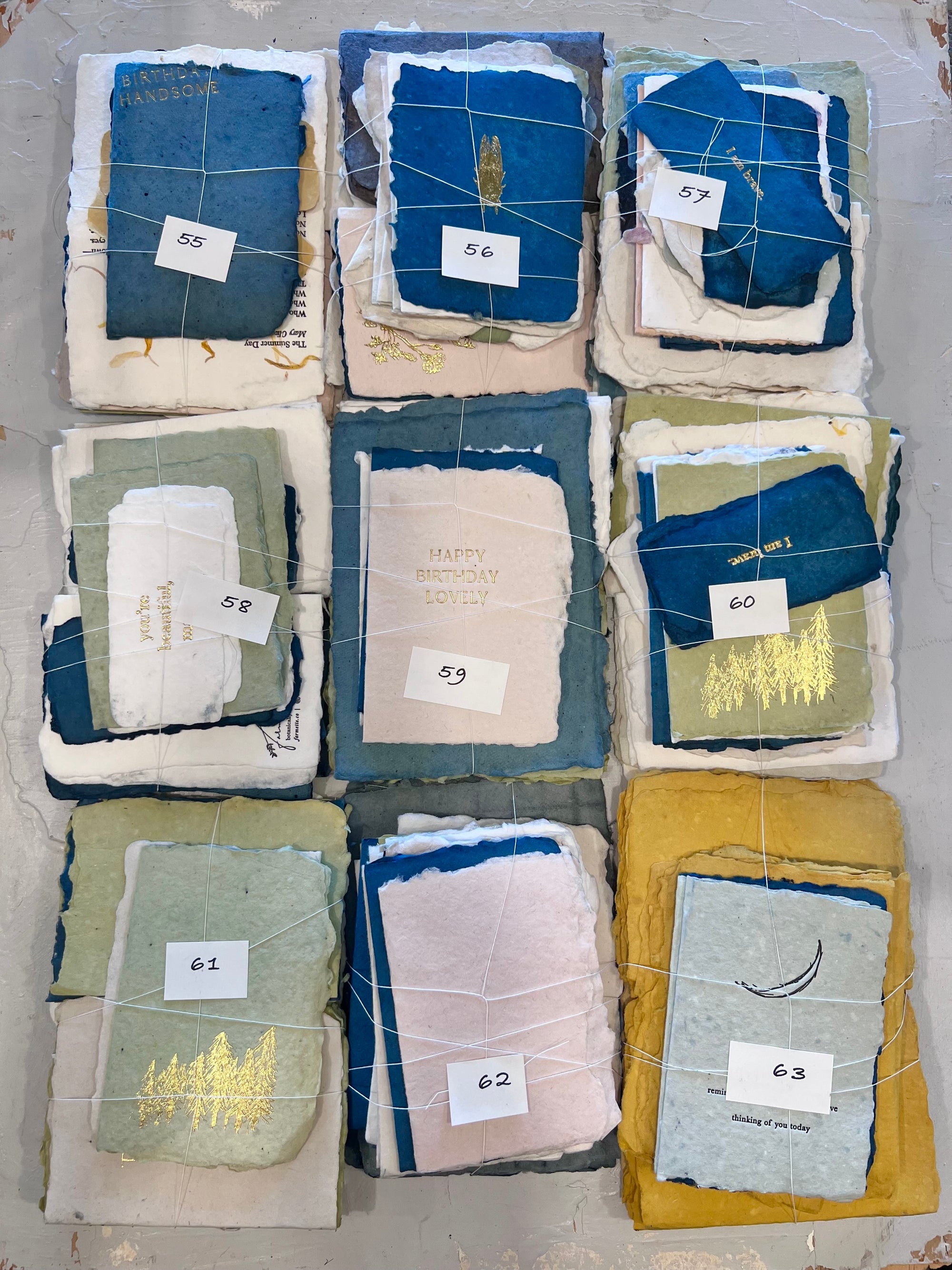 Assorted fabric scrap bundles with numbered tags 55–63, stacked in squares