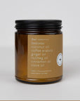 Brown glass beeswax jar candle labeled with essential oil ingredients and black lid