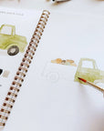 Autumn watercolor workbook close view of painted truck on page with brush in hand