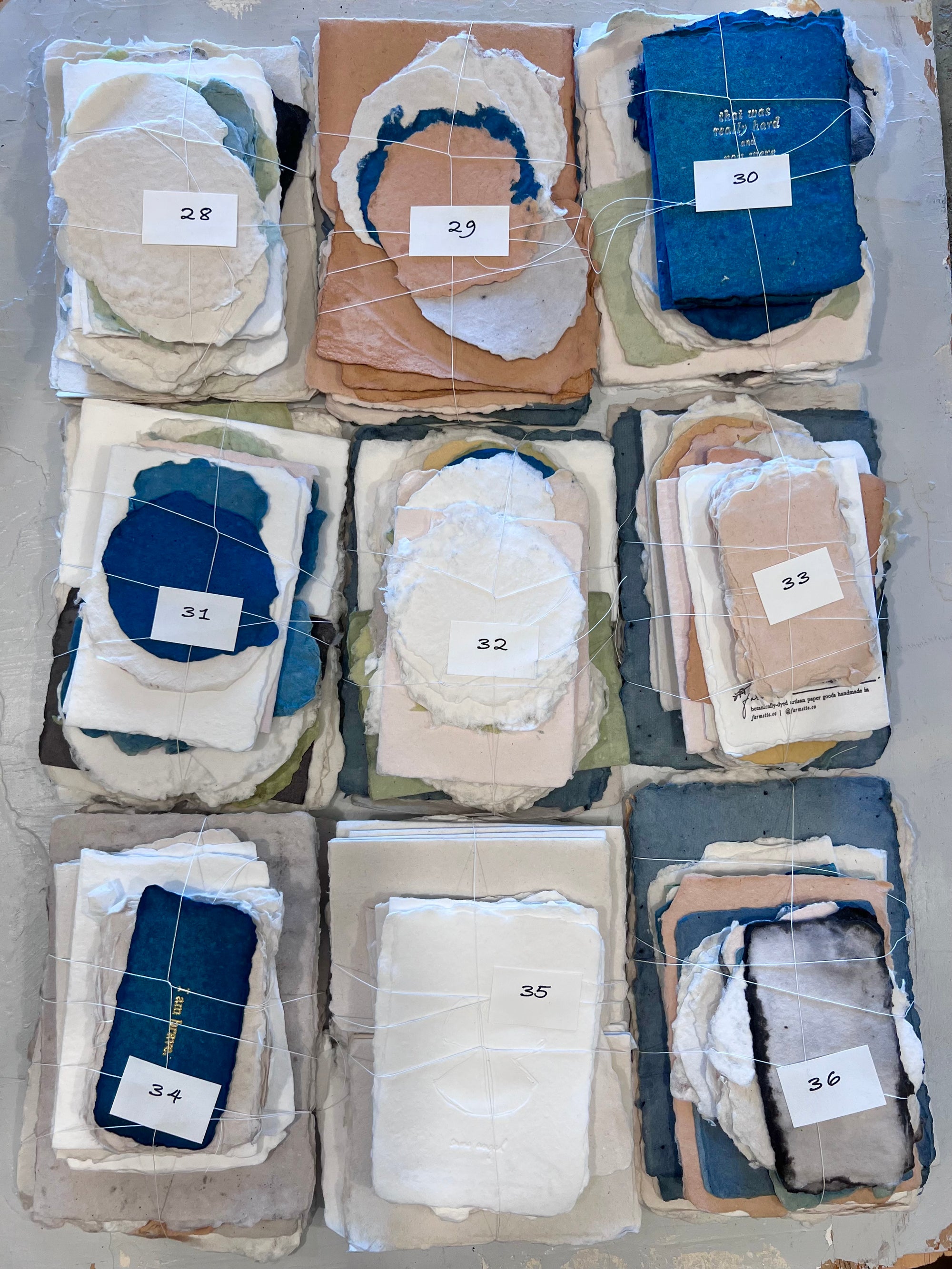 Assorted fabric odds bundles, numbered stacks 28–36 in light beige and blue