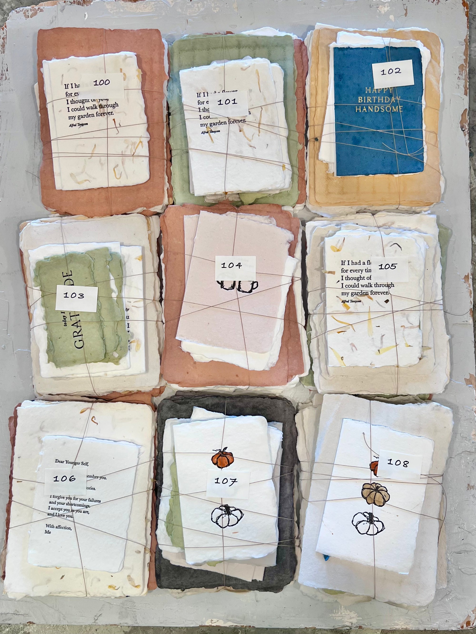Set of numbered handmade paper card bundles, featuring 100–108 labels
