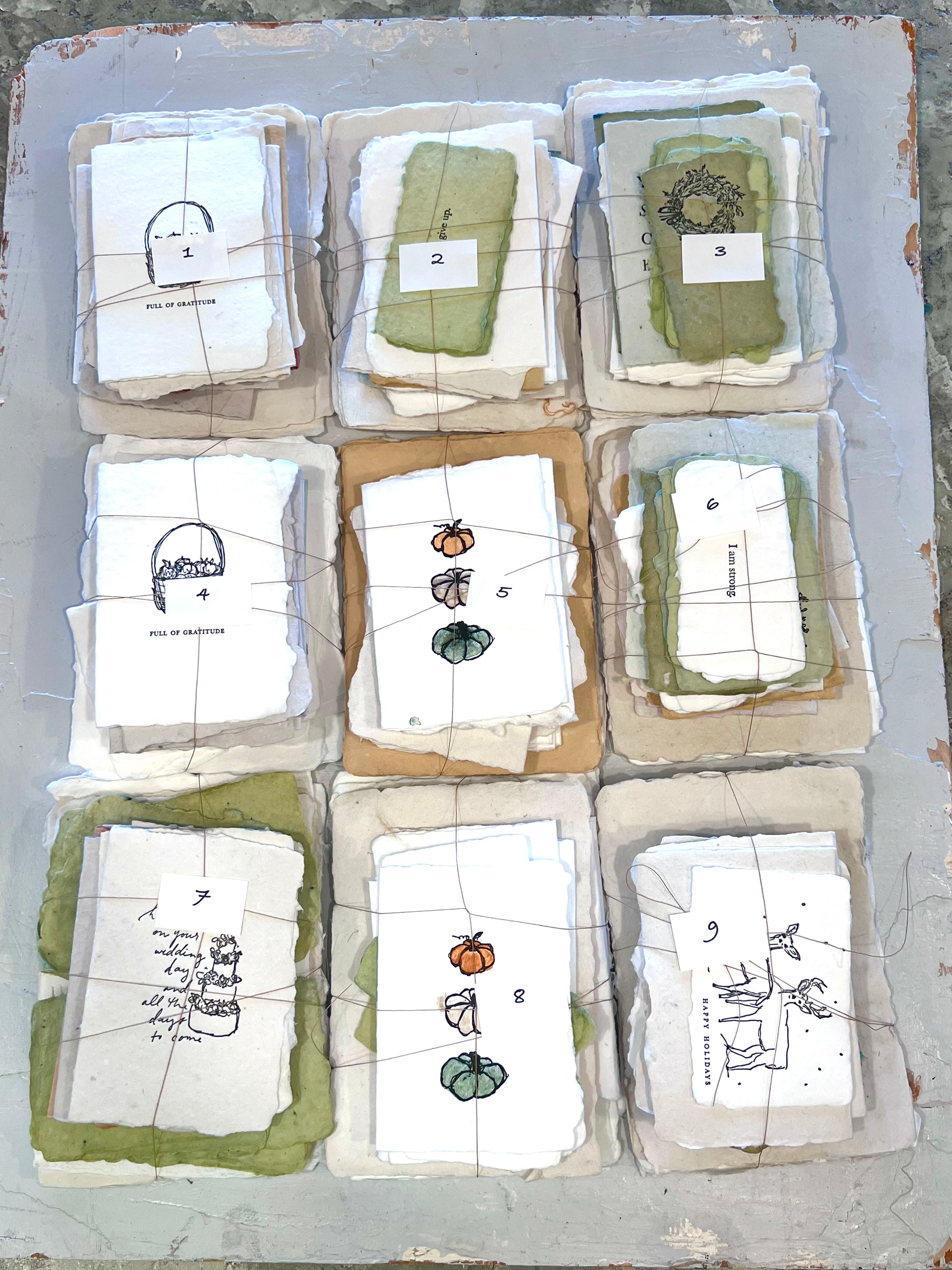 Odds bundles 001-009: nine numbered paper bundle packs with small illustrated cards