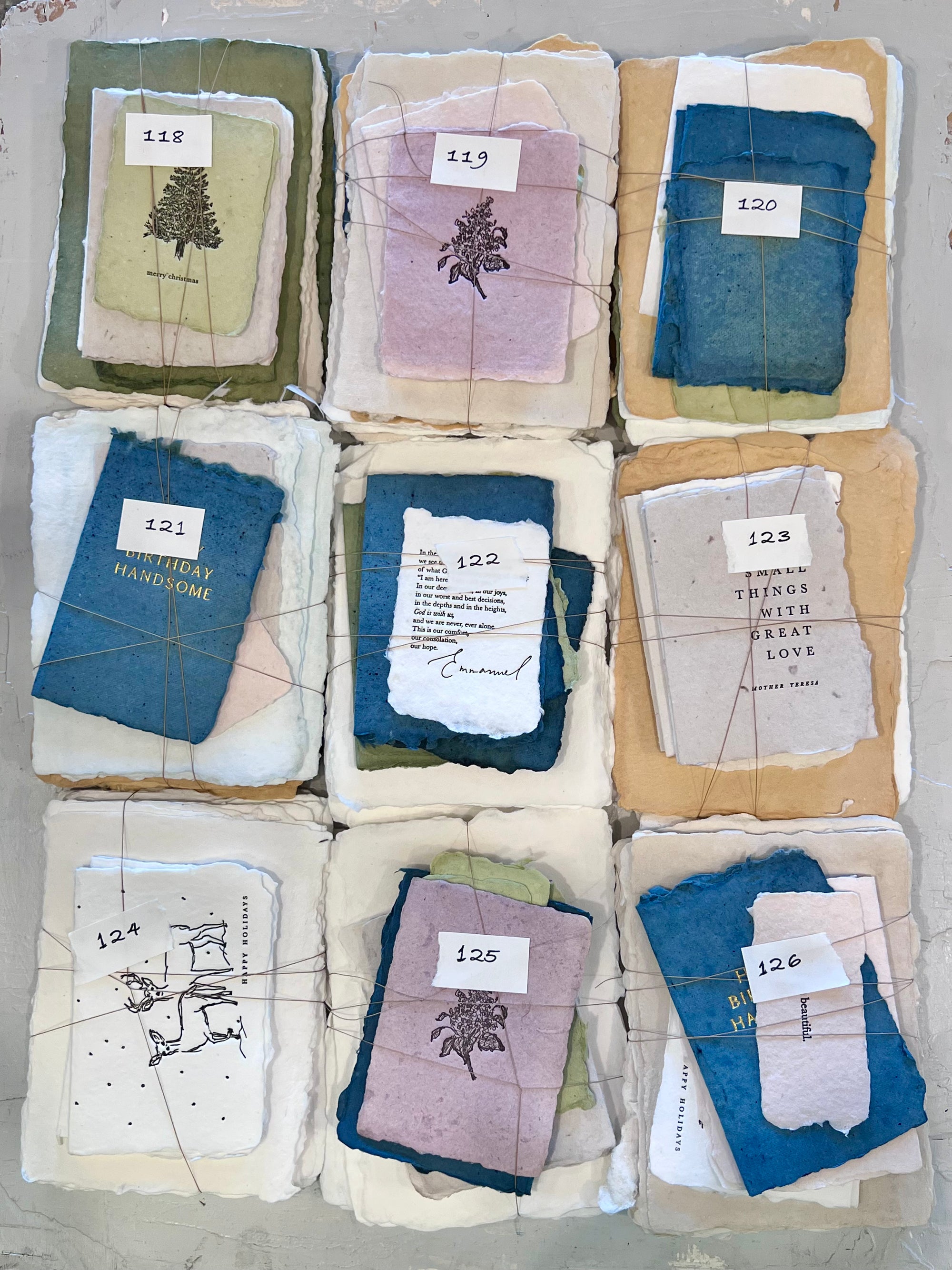 Assorted fabric square bundles with printed motifs, labeled 118–126