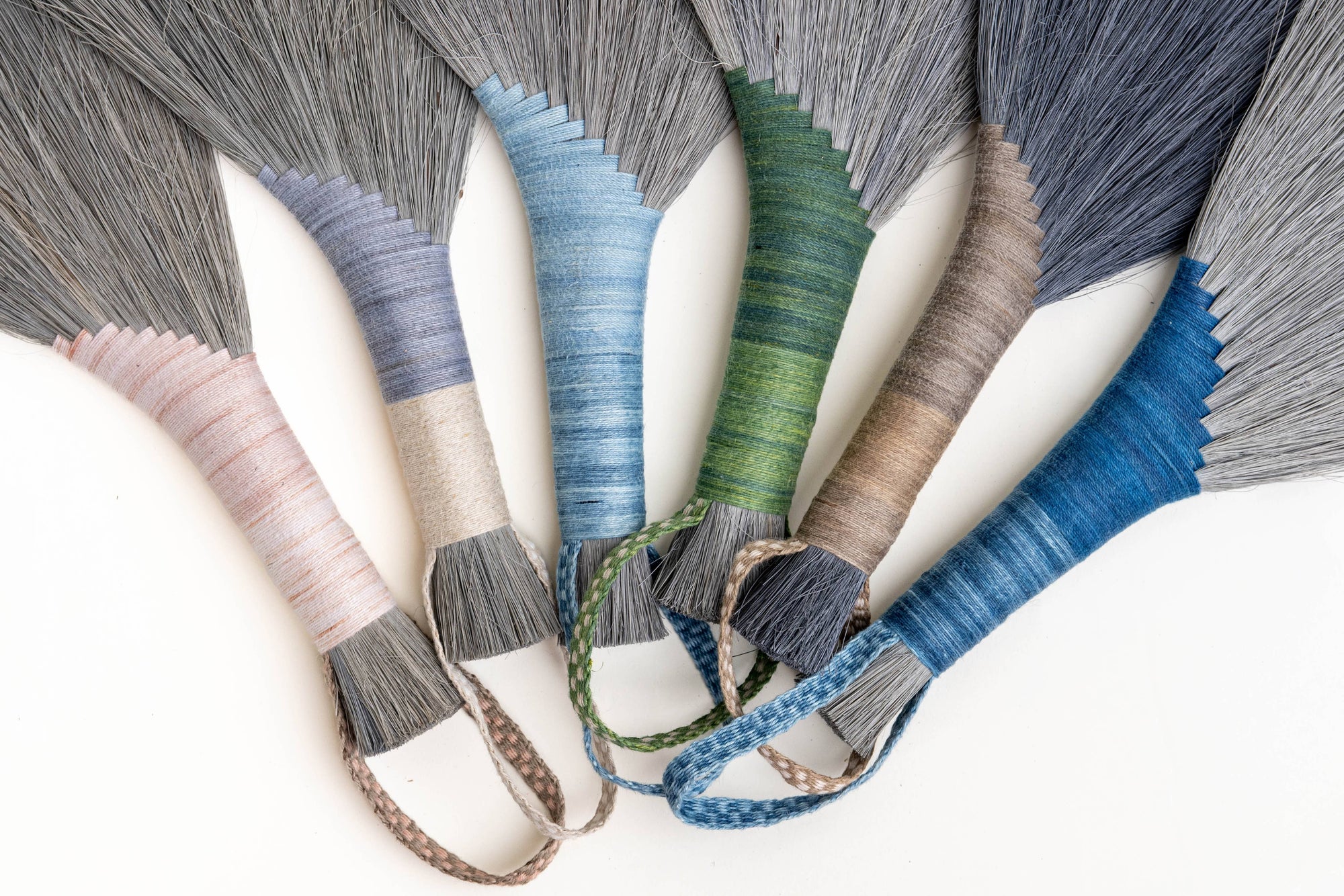 Tampico wing brush close-up with gray bristles and blue green striped wraps