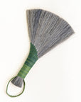 Handheld wing broom with gray fiber head, green wrapped handle, and green cord loop