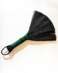 Tampico wing brush with dark bristles, green handle, and black leather cord loop