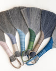 Fan array of wing brooms with gray, blue, green, pink, and navy fiber heads
