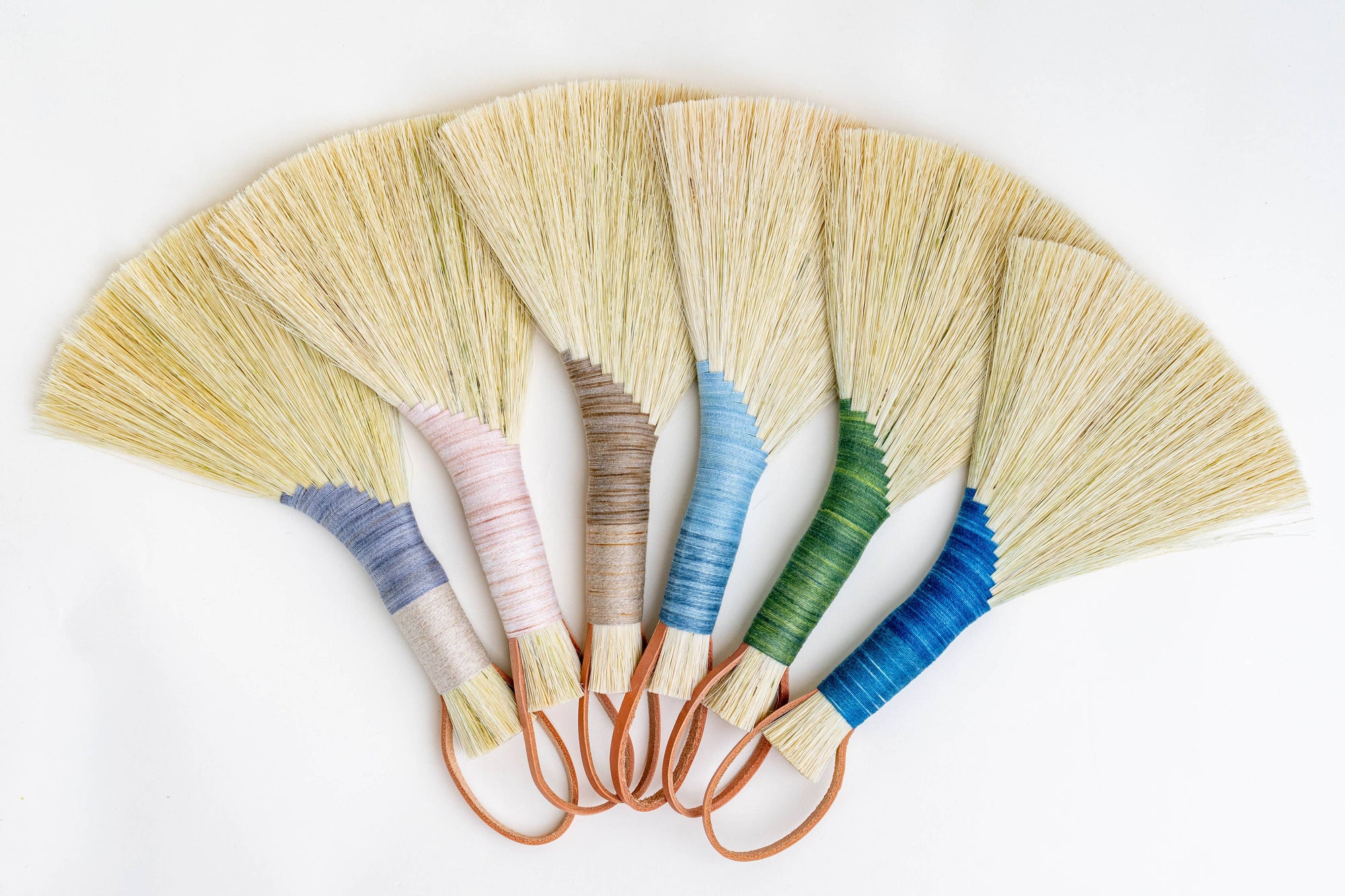 Set of wing brooms with mixed wrapped handles and tan tampico bristles