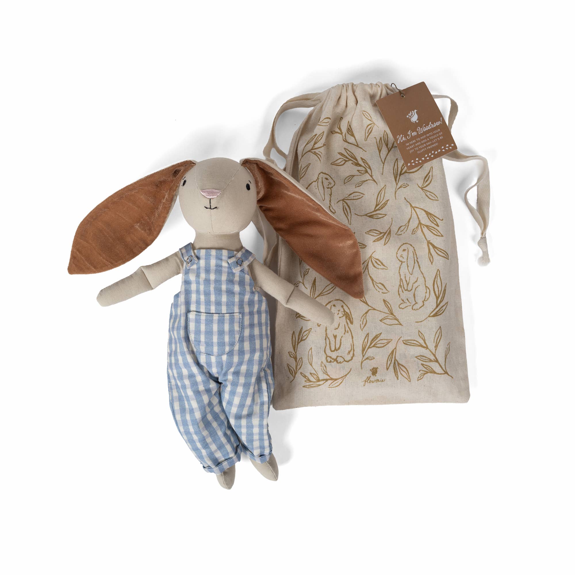 Rabbit plush doll with blue striped overalls beside a leaf-print drawstring bag