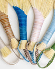 Tampico wing brush set close-up of yellow bristle fans with braided cords and straps