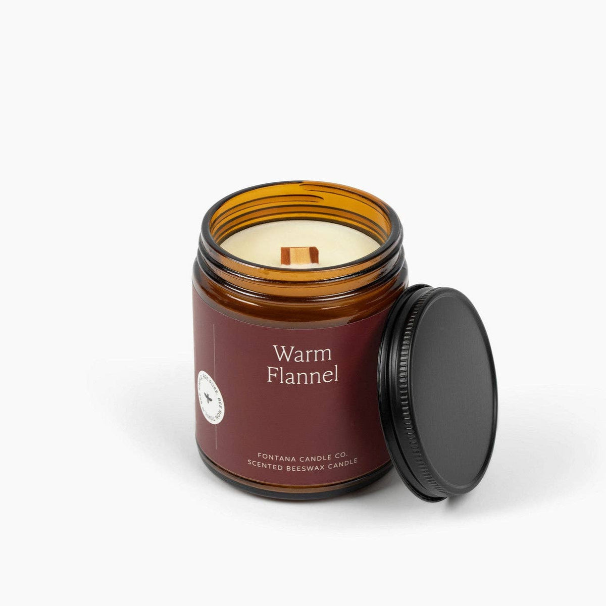 Warm Flannel candle jar with black lid; white wax visible at top