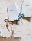 Vow book with white cover and blue ribbon tie bow